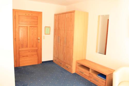 a bedroom with a wooden cabinet and a door at Gasthaus Stefaner in Feistritz im Rosental