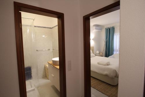 uma casa de banho com um chuveiro e um quarto com uma cama em Vale Caranguejo em Tavira