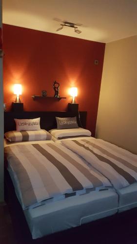 a bedroom with a large bed with two lamps on it at Lieblings-Platz in Langelsheim