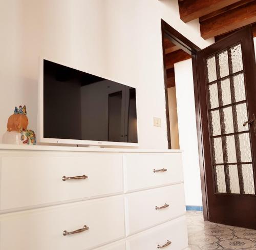 a white dresser with a tv on top of it at Il Grazioso Giardinaccio in Palermo