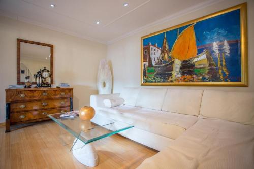 a living room with a white couch and a painting at Villa Penkala Apartment in Opatija