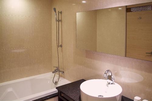 uma casa de banho com um lavatório, uma banheira e um espelho. em SLV Hotel Group-SLV Business Hotel em Zhonghe