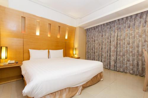 a bedroom with a large white bed and a window at SLV Hotel Group-SLV Business Hotel in Zhonghe