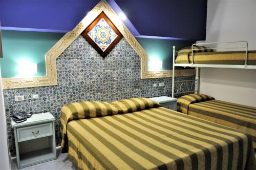 a hotel room with two beds and a ceiling at Al-Tair in San Vito lo Capo