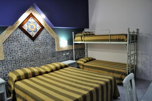 a room with two beds and a bunk bed at Al-Tair in San Vito lo Capo