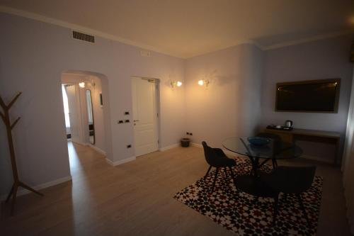 a living room with a glass table and chairs at Les 7 Suites Erica in Grado