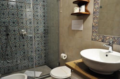 a bathroom with a shower and a sink and a toilet at Al-Tair in San Vito lo Capo