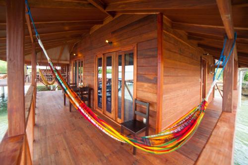 a hammock on a porch of a house at Aqui hoy cabañas in Bocas del Toro