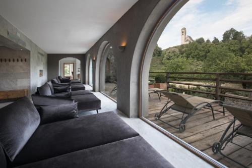 a room with couches and a balcony with a view at Gartenhotel Völser Hof - Adults Only in Fiè