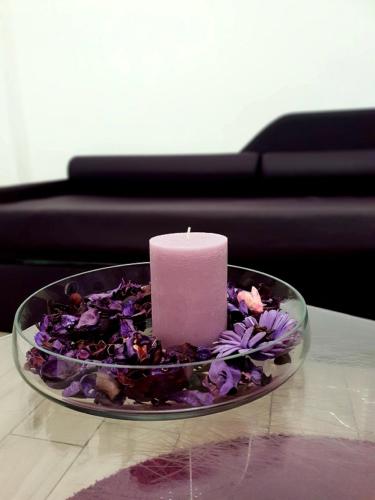 a candle on a plate with flowers on a table at Etna Suite Group in Catania