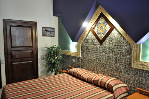 a bed in a room with a wall at Al-Tair in San Vito lo Capo