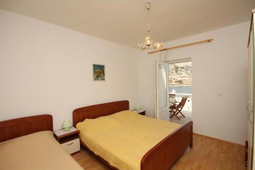 a bedroom with two beds and a view of a patio at Apartments Niko Metajna, island Pag in Metajna