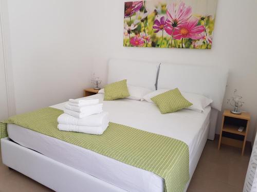 ein weißes Bett mit einem Haufen Handtücher drauf in der Unterkunft B&B Fior di Mare in Porto Cesareo
