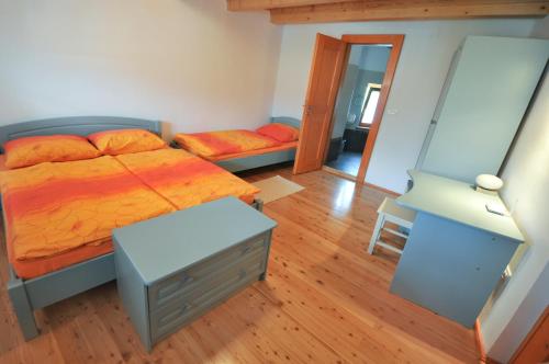 a bedroom with a bed and a dresser and a mirror at Apartments Tonkli in Logje