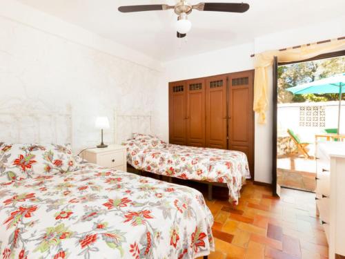 ラ・エラドゥーラにあるChalecito en la Herradura- Casa Kwetuのベッドルーム1室(ベッド2台、シーリングファン付)