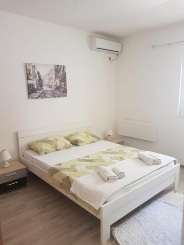 a white bedroom with a bed in a room at Apartments Peđa in Sveti Stefan