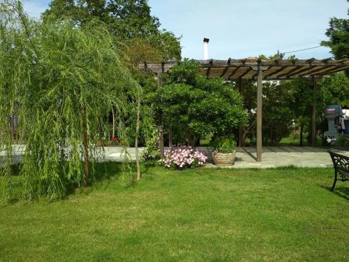 a park with a bench and flowers in the grass at Pelion Platanidia seaside house in Platanidia