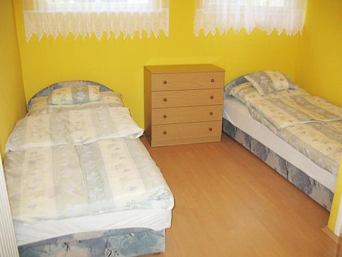 a bedroom with two twin beds and a dresser at Apartman Alexa in Ábrahámhegy