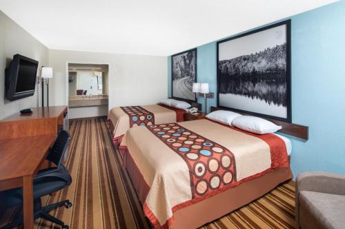 a hotel room with two beds and a desk at Super 8 by Wyndham Burlington NC in Burlington