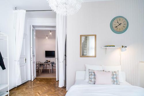ブダペストにあるNine Trees Apartmentのベッドルーム1室(ベッド1台、壁掛け時計付)