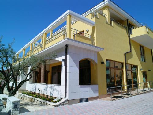 a yellow building with a balcony on top of it at Vilola in Umag