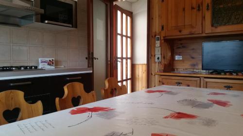 a kitchen with a table with red flowers on it at Eureka Azienda Agrituristica in Cavallino-Treporti