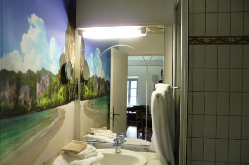 La salle de bains est pourvue d'un lavabo et d'une peinture murale. dans l'établissement La Maison Bleue d'Ardèche, à Saint-Mélany