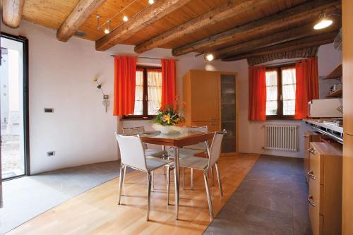 a kitchen with a table and chairs in a room at La Casetta in Piazzetta in Cormòns