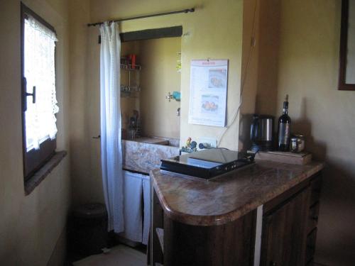 una cucina con bancone, lavandino e finestra di S. Bartolomeo II° - "La Loggetta" a Montepulciano