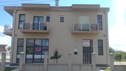 a large white building with two balconies on it at Apartments Delić in Nikšić