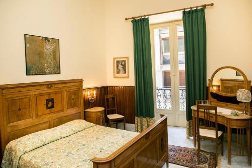 een slaapkamer met een bed, een bureau en een raam bij B&B Santa Caterina in Palermo