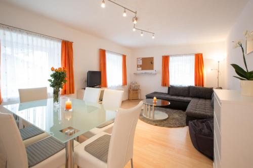 a dining room and living room with a glass table and chairs at Apart Hofer in Nauders