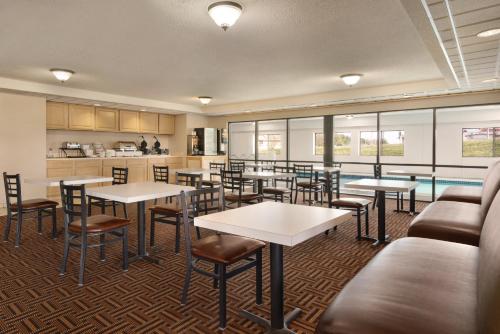 a restaurant with tables and chairs and a pool at Super 8 by Wyndham Chambersburg I-81 in Chambersburg