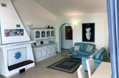 un soggiorno con divano blu e TV di Villa Maddalena - Giardinelli a La Maddalena