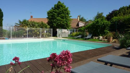 - une piscine dans une cour ornée de fleurs violettes dans l'établissement La Boisnière, à Mouilleron-en-Pareds