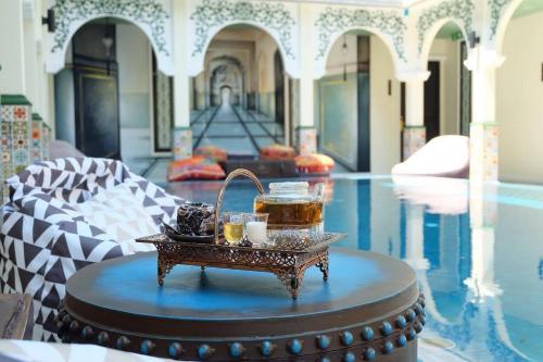 un vassoio di cibo su un tavolo accanto alla piscina di Palette The Grand Morocc Hotel a Mae Rim