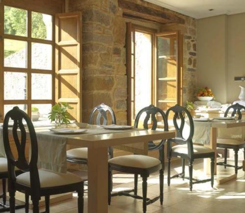 a dining room with a wooden table and chairs at Narbasu Restaurante y Hotel in Cereceda