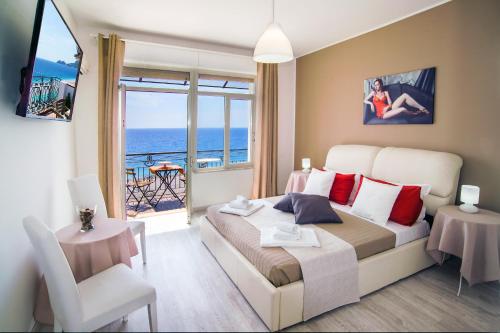 - une chambre avec un lit et une vue sur l'océan dans l'établissement Loft Vista Sul Mare, à Letojanni