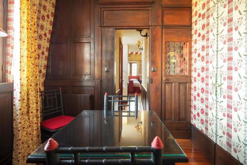 a dining room with a table and a wall with a curtain at La Maison Des Vieux Logis in Rouen