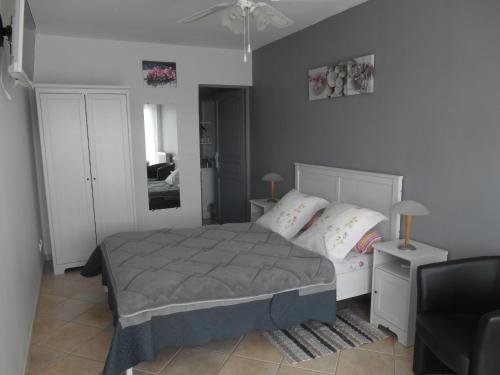 a bedroom with a bed and a couch and a chair at Chambres d'hôtes LA COZY in Cozes