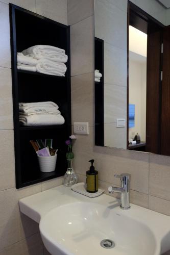 a bathroom with a sink and a mirror and towels at Moonlit Seaview Homestay in Donghe