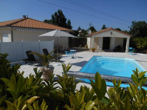 a villa with a swimming pool and a house at Chambres d'hôtes LA COZY in Cozes