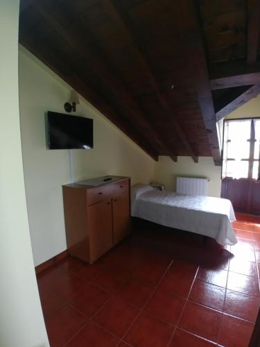 a bedroom with a bed and a flat screen tv at El Pedroso in Santillana del Mar