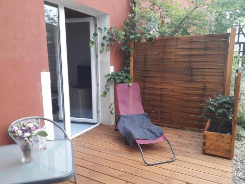 a pink chair sitting on a deck with a table at 1 Zimmer Appartment in Springe
