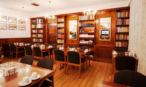 a restaurant with tables and chairs and books at Havly Hotell in Stavanger