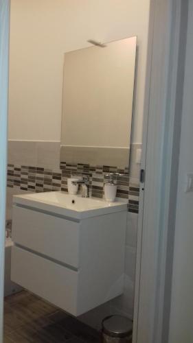a white bathroom with a sink and a mirror at Ca di Ale in Lerici