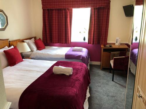 a hotel room with two beds and a window at The Woolaston Inn in Lydney