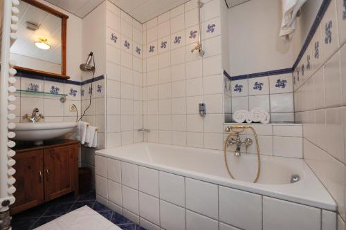 ein Badezimmer mit einer Badewanne und einem Waschbecken in der Unterkunft Villa 17 in Gaschurn
