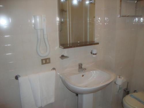 a white bathroom with a sink and a toilet at Hotel Cristal in Roccaraso