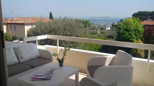 Balcón con sofá, 2 sillas y mesa en Villa Sophora, en Moniga del Garda